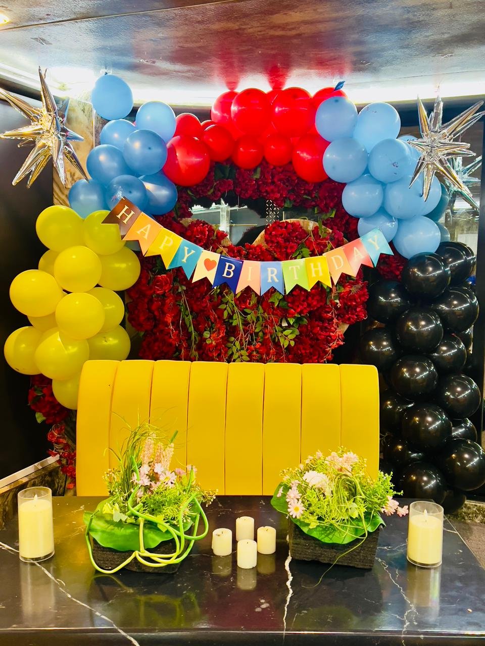 Birthday celebration table with gold decorations on a dhow cruise with Dubai skyline at night